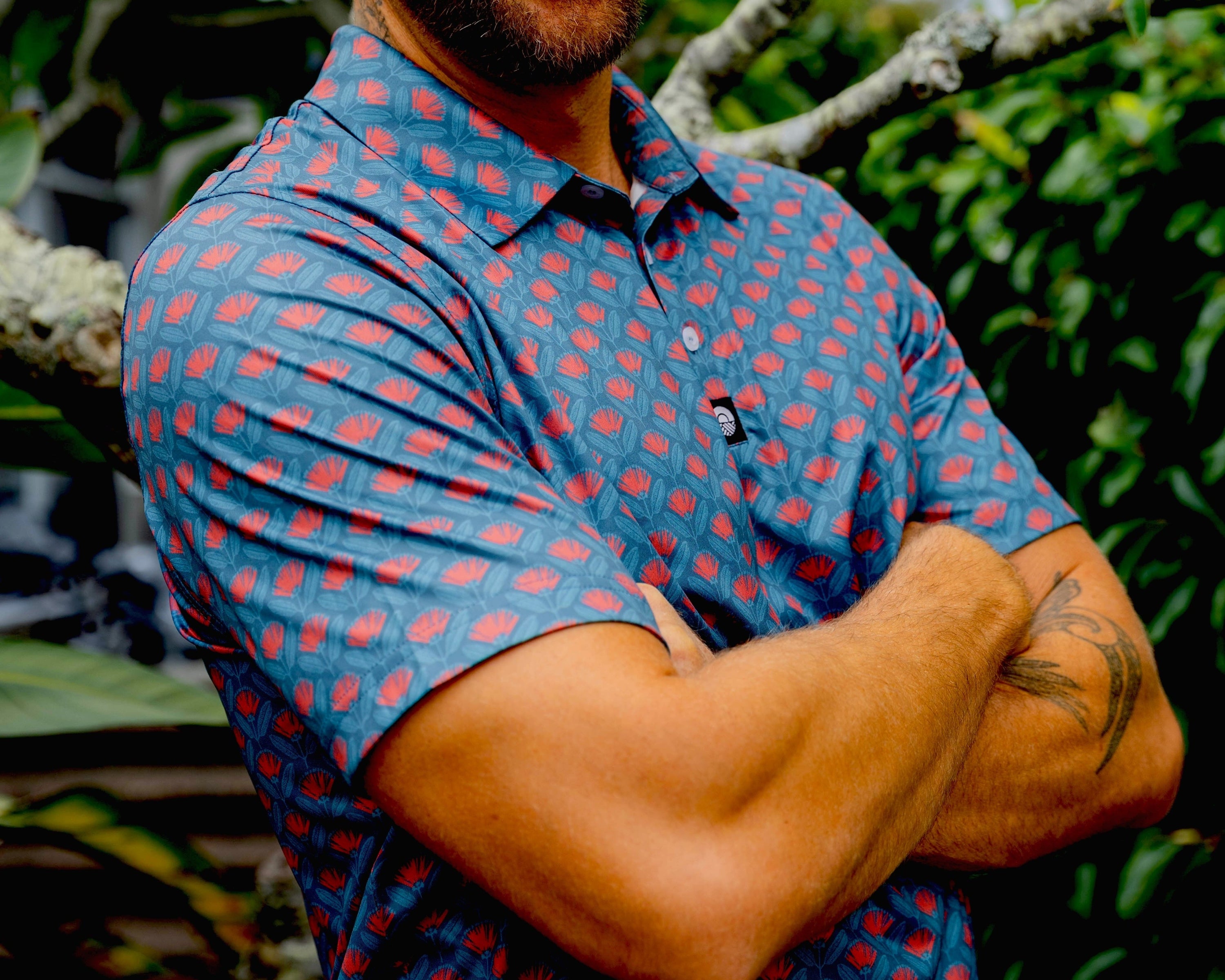 Man wearing a pohutukawa pattern golf shirt