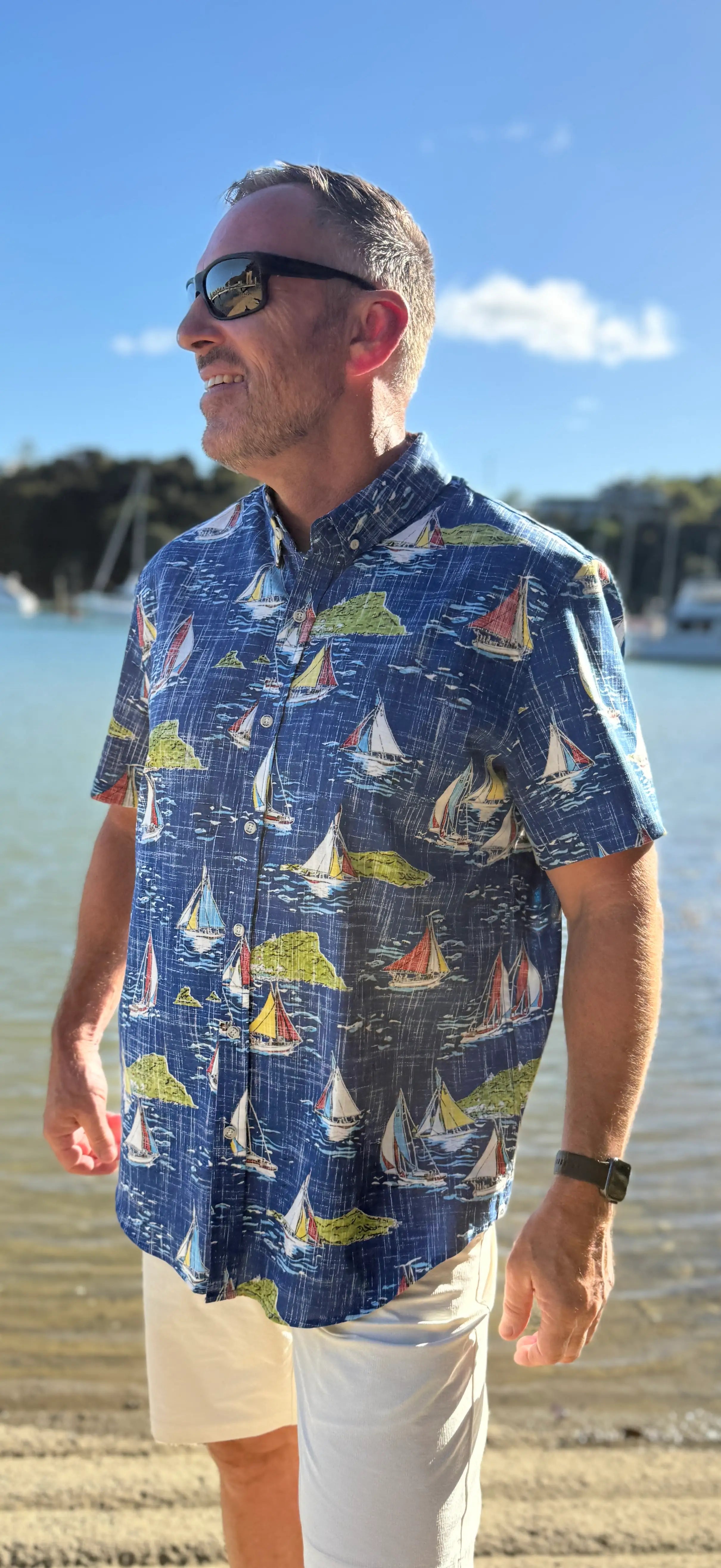 Man wearing a classy blue shirt with sailboats on it.