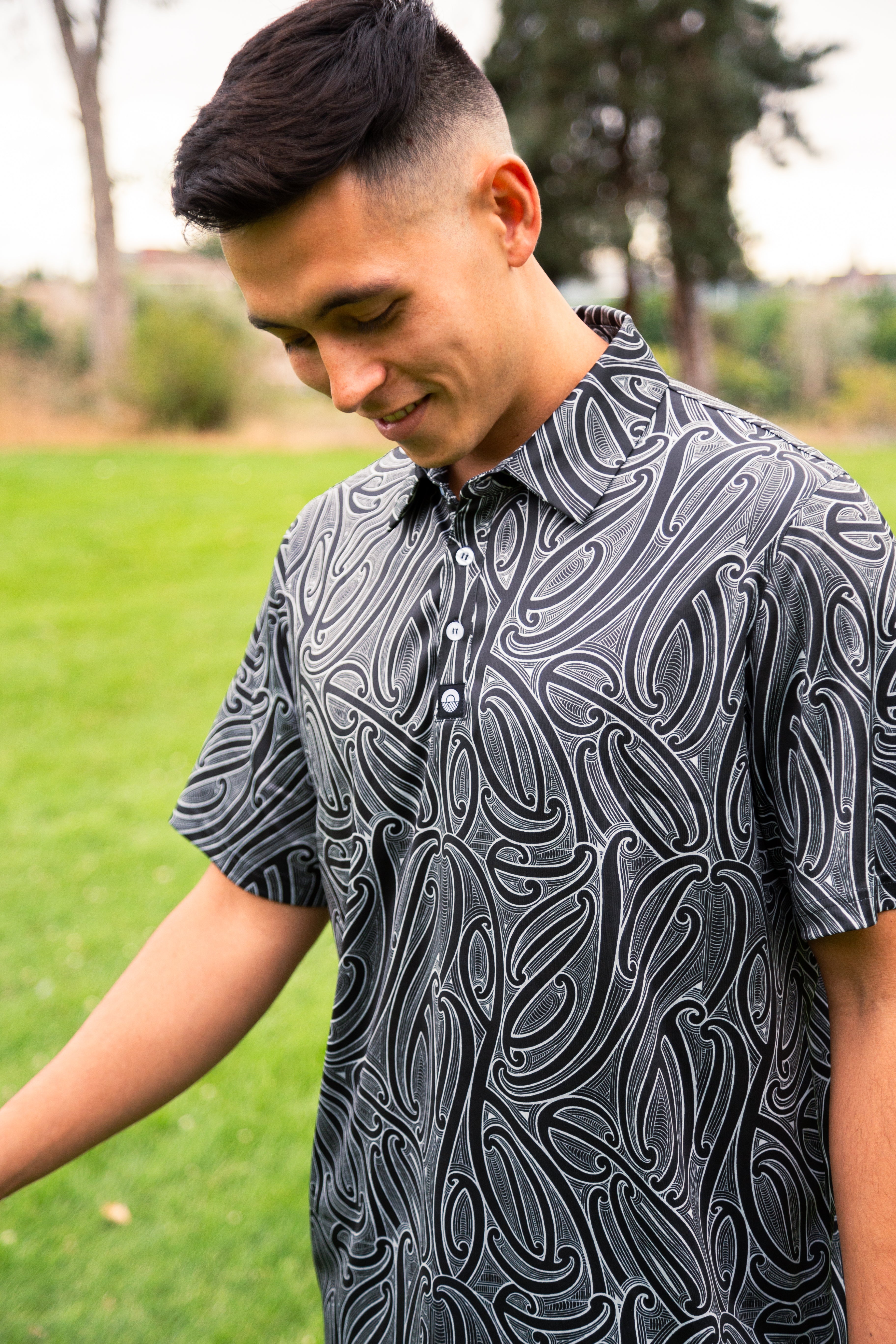 Men’s Kowhaiwhai golf polo shirt featuring bold black and white Māori-inspired design – premium performance golfwear from Kaleo New Zealand