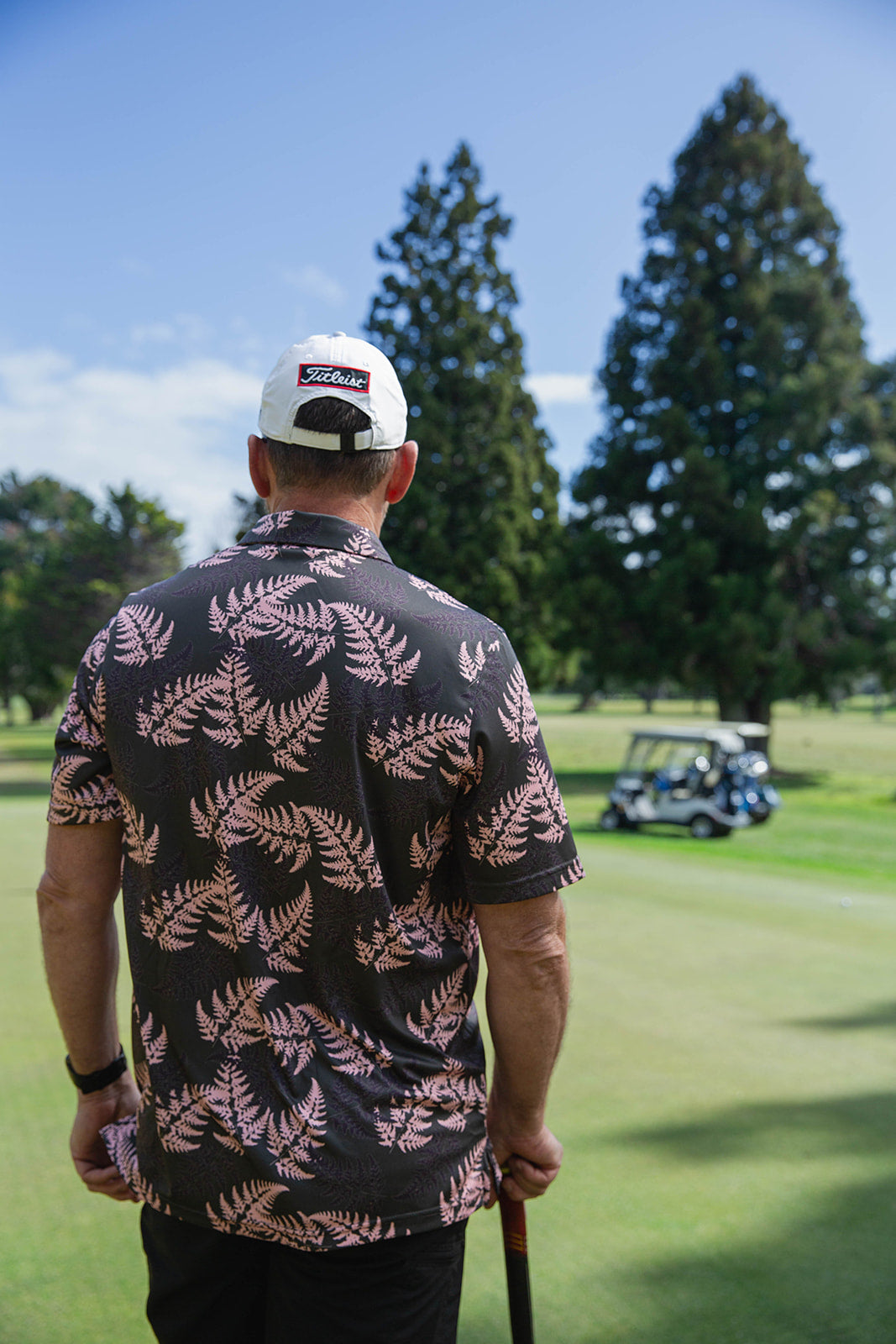 Men’s pink and black golf polo with silver fern print. NZ-designed performance polo shirt for golf, summer wear, and casual Kiwi style.