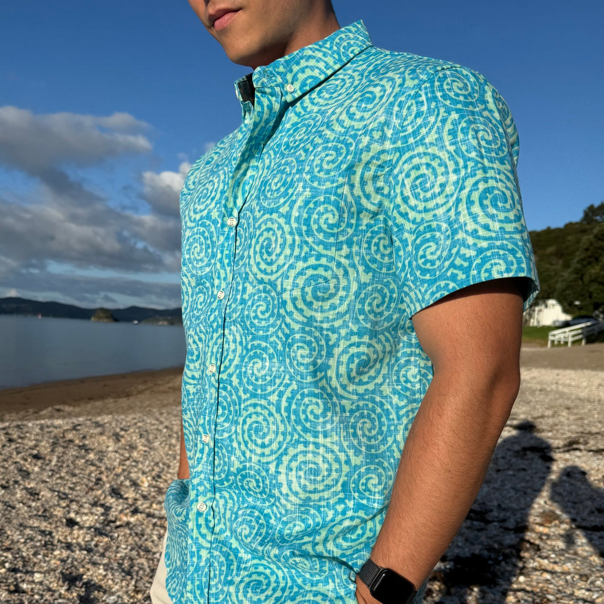 Takarangi Kiwi Classic men's short sleeve shirt in turquoise and ocean blue with traditional Māori spiral motifs.