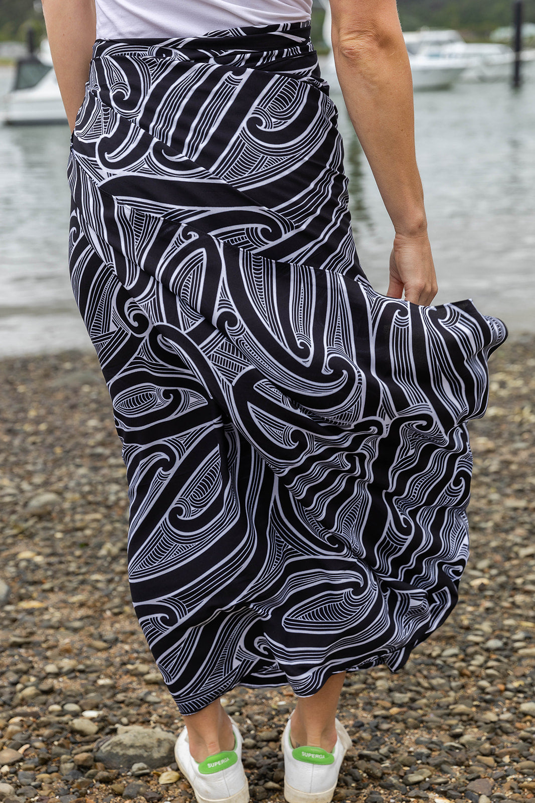 Women’s beachwear NZ – Kōwhaiwhai sarong with Māori-inspired design, NZ-designed wearable art by Kaleo. Lightweight holiday clothing and unique Kiwi gift
