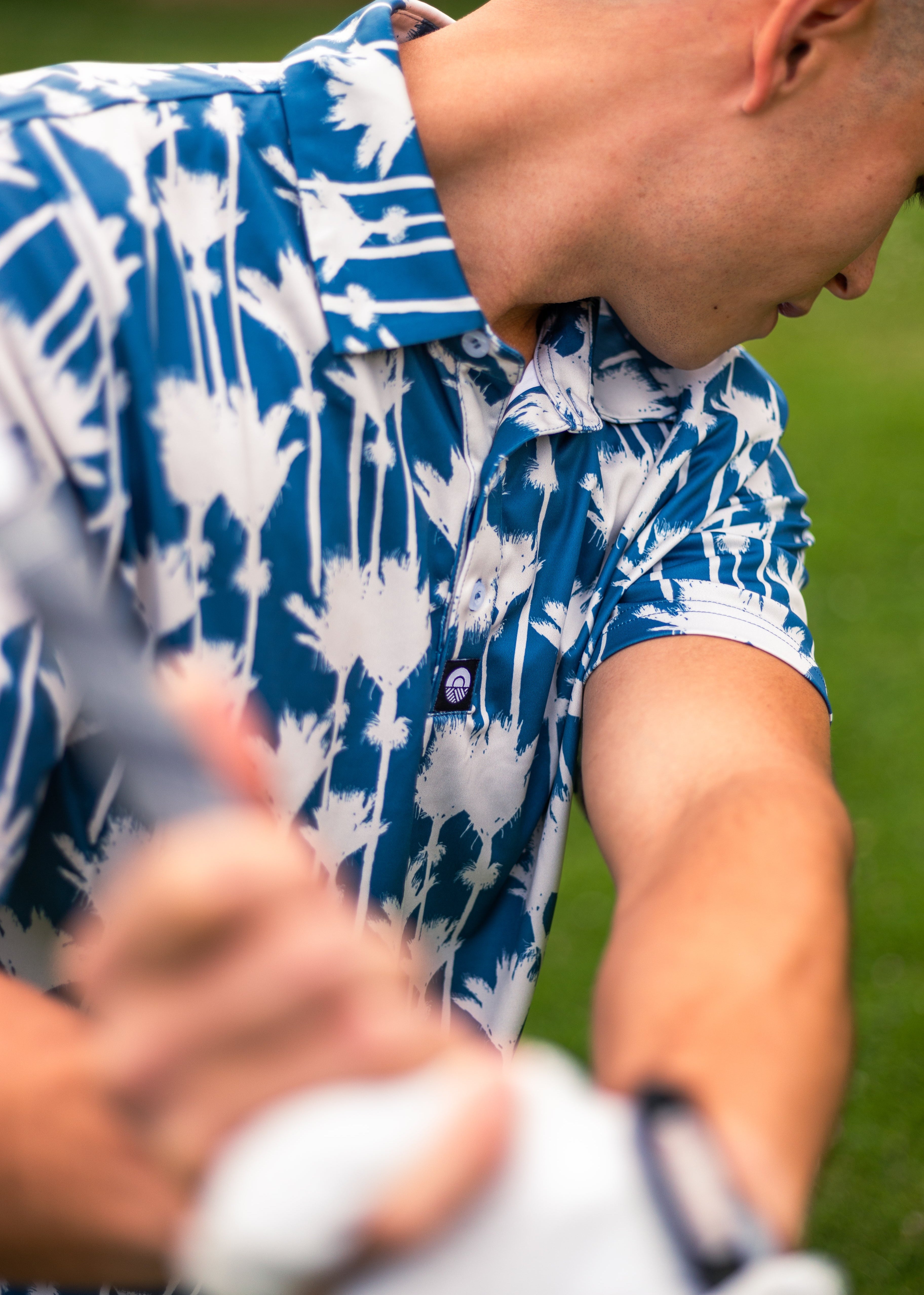 Men’s Nikau Palm golf polo shirt in blue and white with bold New Zealand native palm print – stylish and breathable golfwear by Kaleo