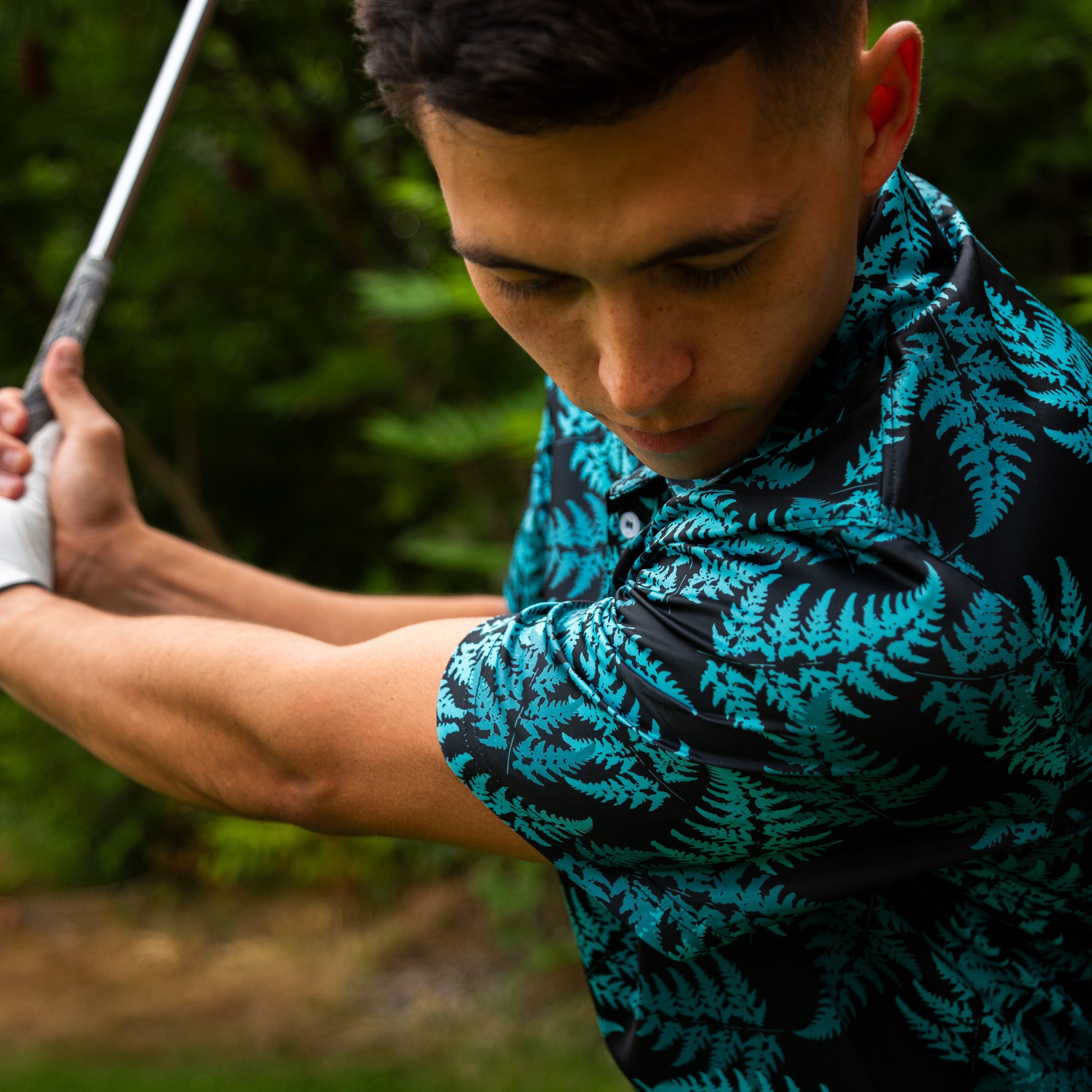 Men’s teal silver fern golf polo shirt with New Zealand native fern design – breathable, performance golfwear by Kaleo