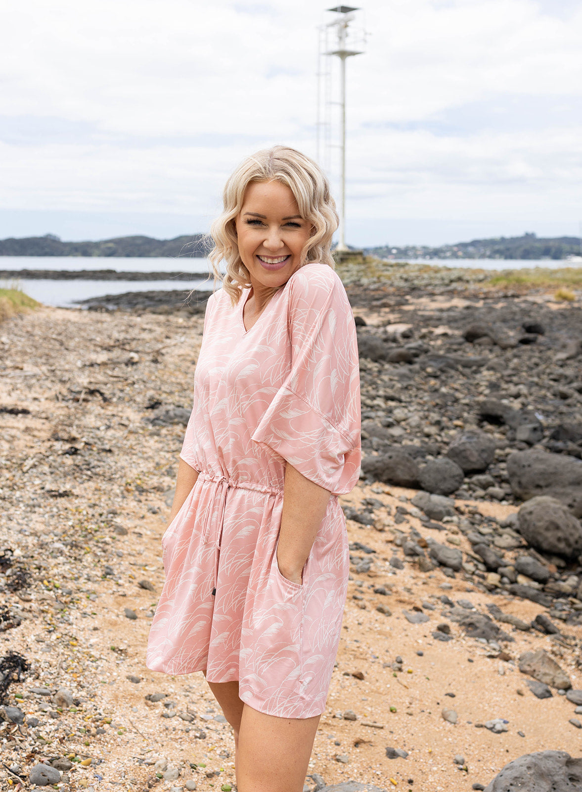 Women’s pink playsuit with white toe toe fern pattern – lightweight New Zealand inspired summer outfit with drawstring waist and short sleeves