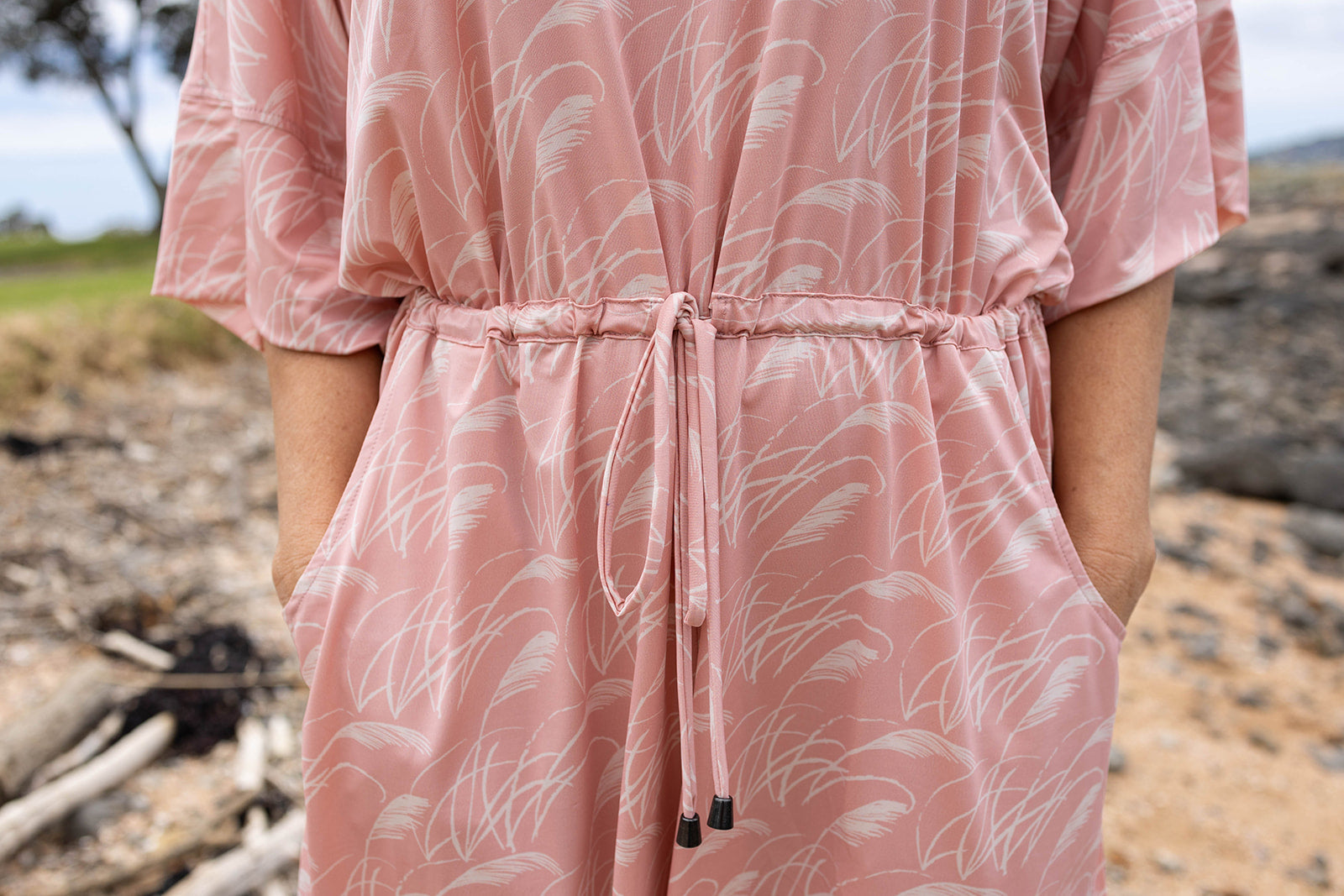 Women’s pink playsuit with white toe toe fern pattern – lightweight New Zealand inspired summer outfit with drawstring waist and short sleeves