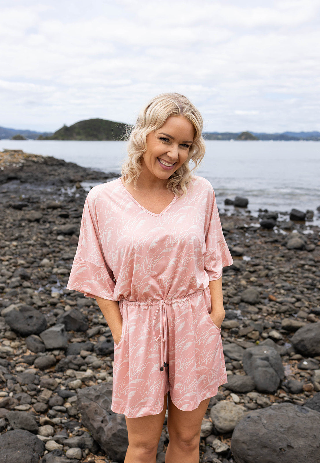 Women’s pink playsuit with white toe toe fern pattern – lightweight New Zealand inspired summer outfit with drawstring waist and short sleeves