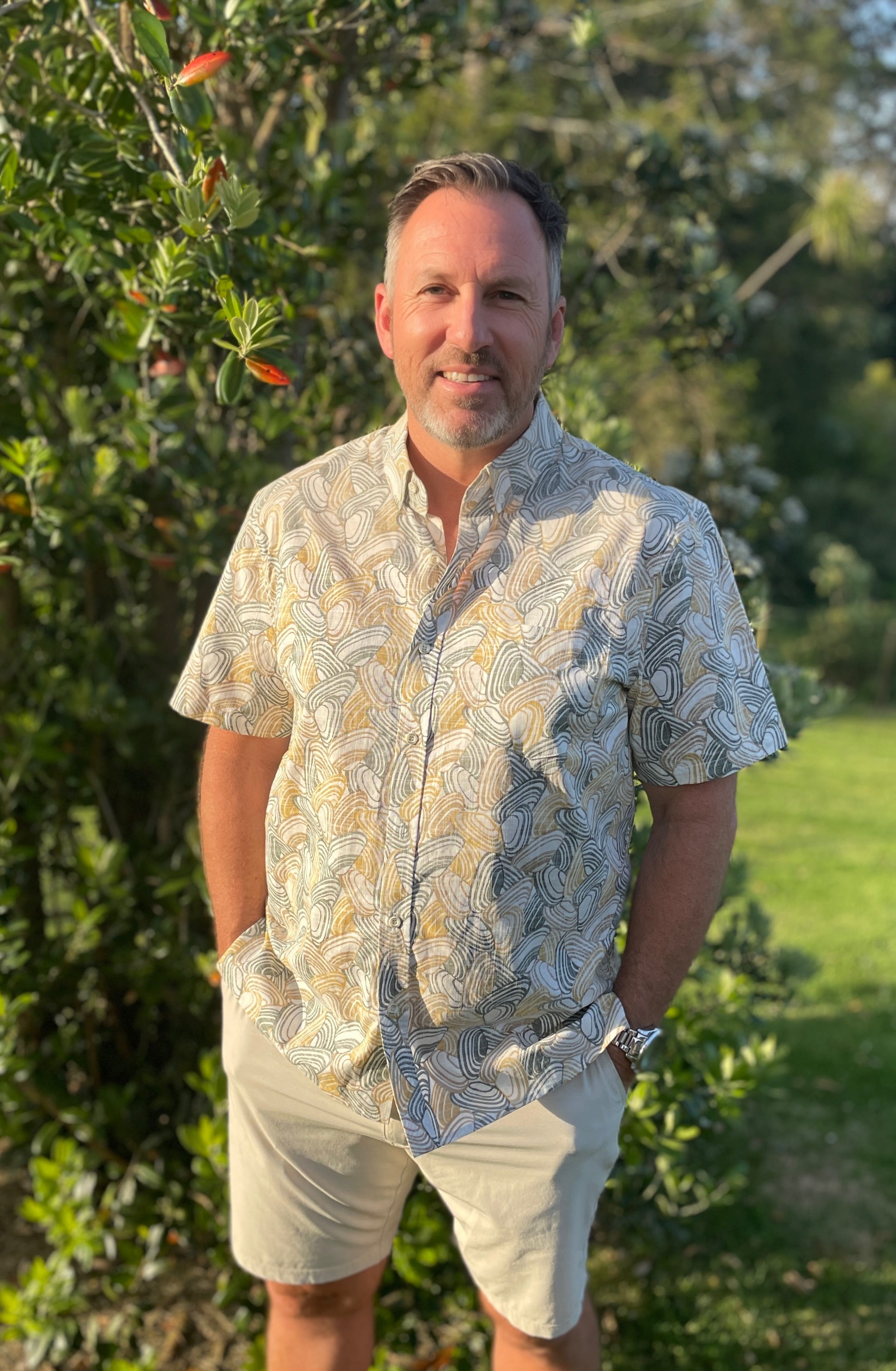 Men’s Pipi Shells Kiwi Classic short sleeve shirt in a coastal seashell print. Lightweight NZ summer shirt, casual beachwear, inspired by Kiwi lifestyle.