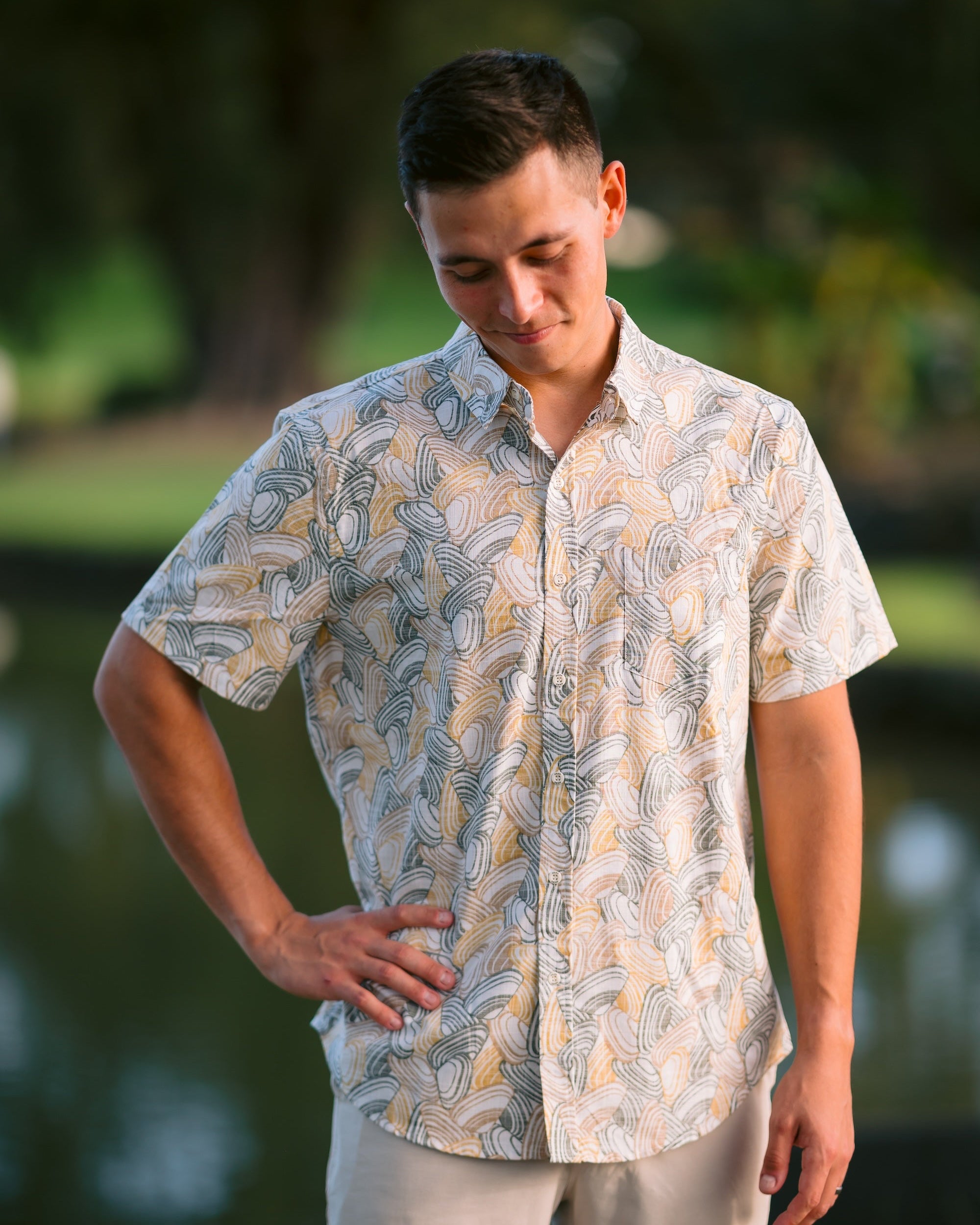 Men’s Pipi Shells Kiwi Classic short sleeve shirt in a coastal seashell print. Lightweight NZ summer shirt, casual beachwear, inspired by Kiwi lifestyle.