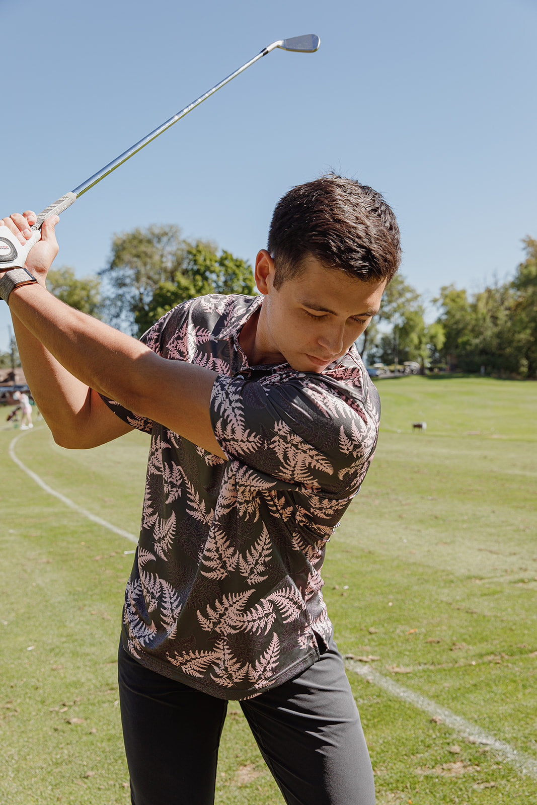 Men’s pink and black golf polo with silver fern print. NZ-designed performance polo shirt for golf, summer wear, and casual Kiwi style.