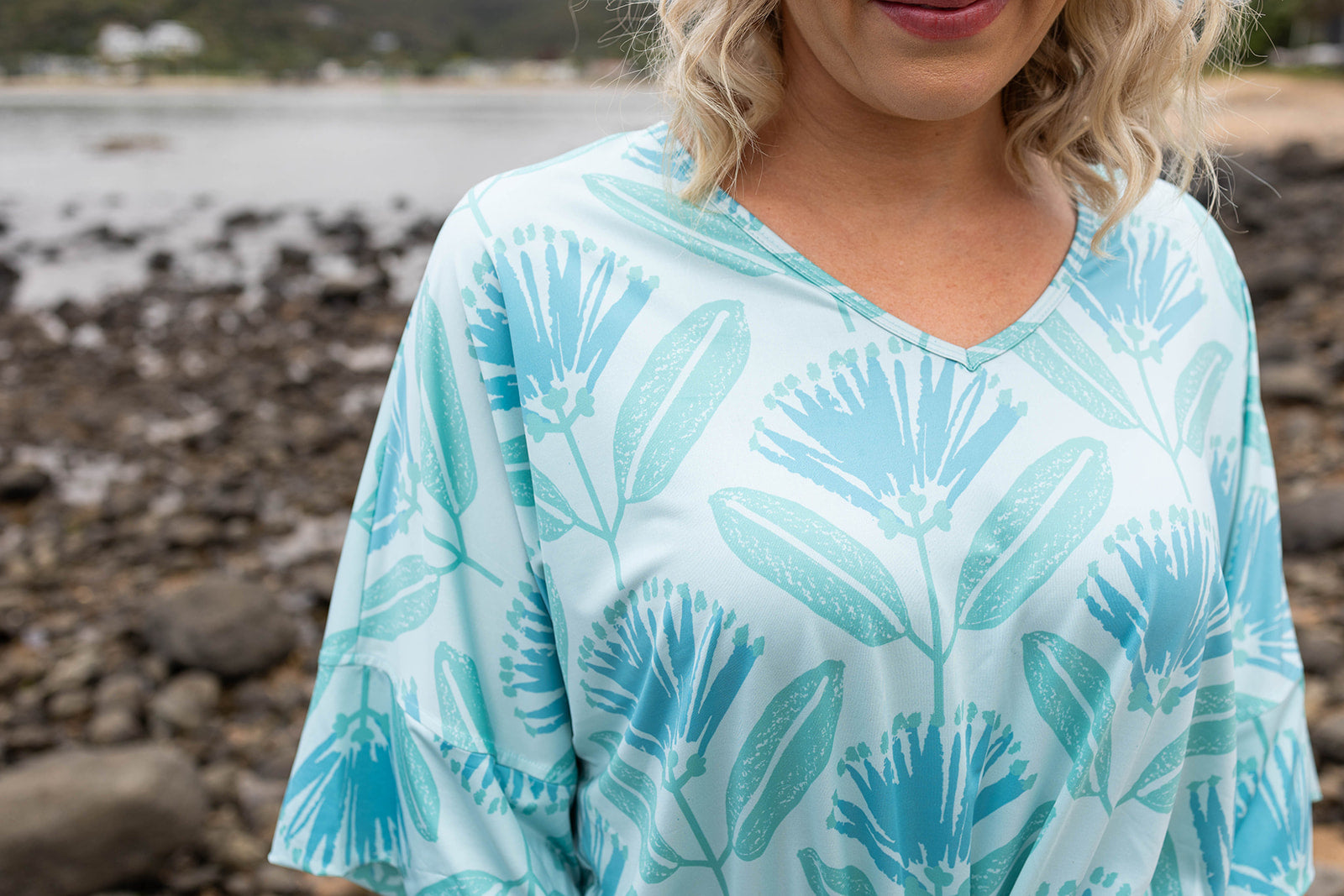 Women’s aqua blue playsuit with Pohutukawa flower print – lightweight summer outfit with drawstring waist, short sleeves, and pockets, inspired by New Zealand flora