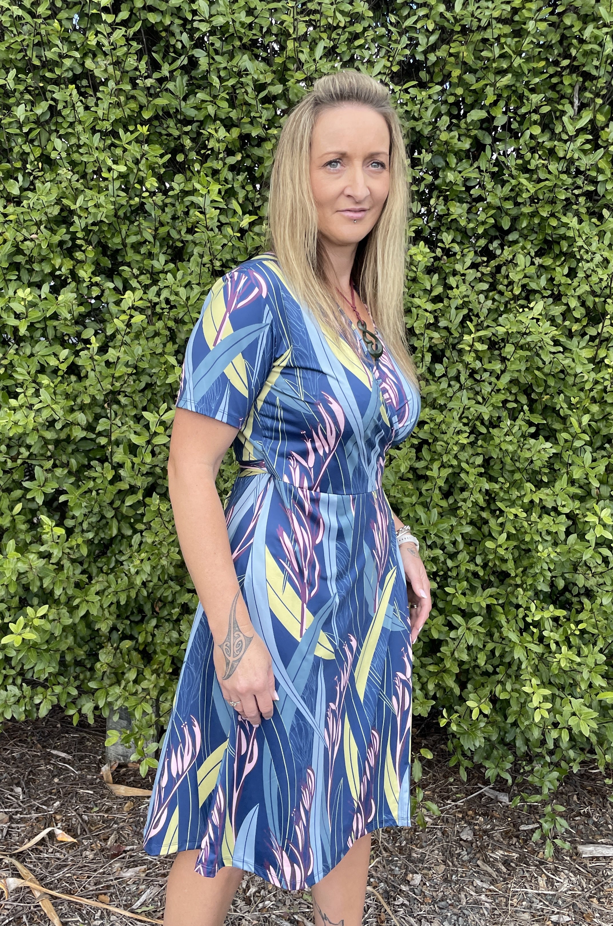 Women’s wrap dress in blue Harakeke flax print – stylish New Zealand inspired dress with short sleeves and flowing fit.