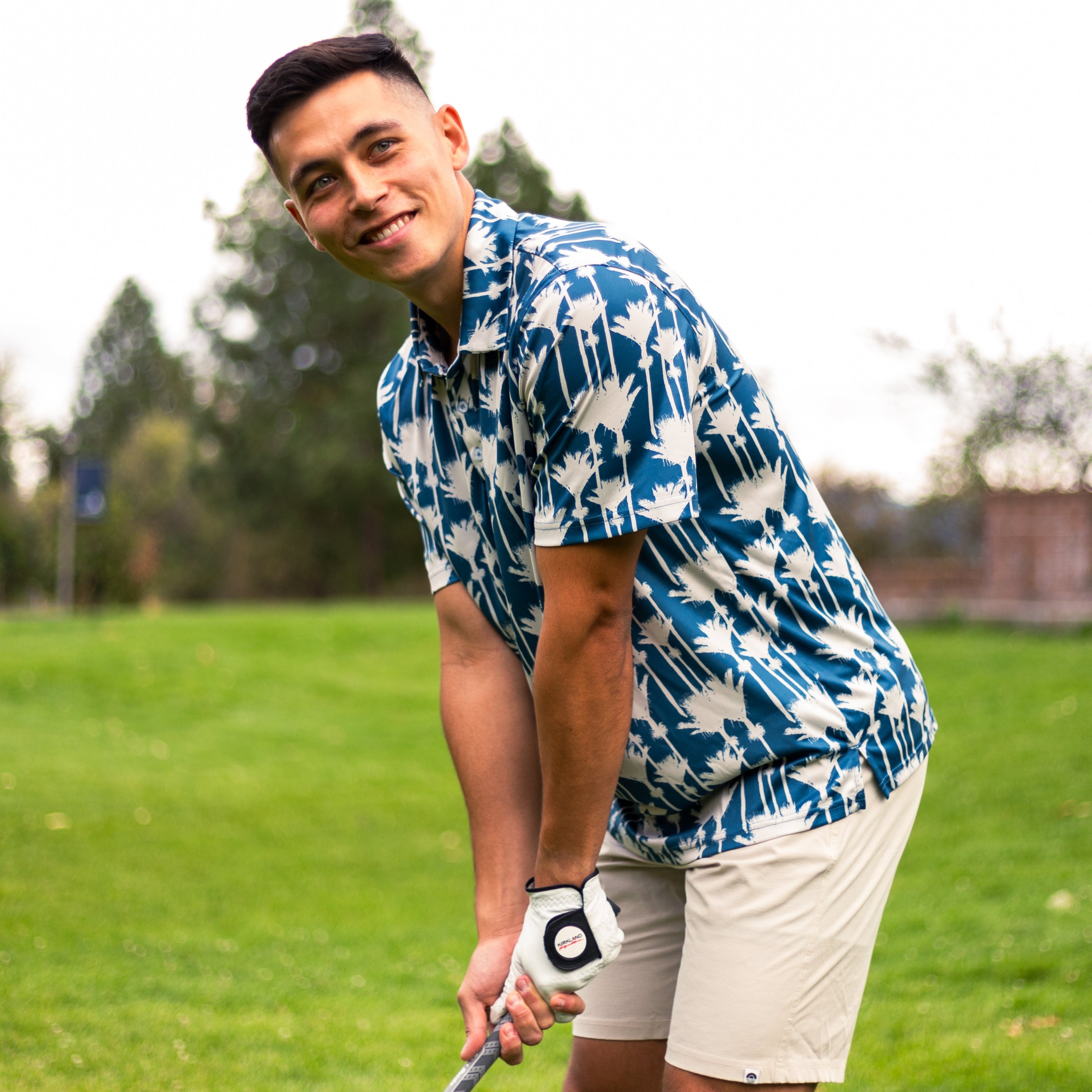 Men’s Nikau Palm golf polo shirt in blue and white with bold New Zealand native palm print – stylish and breathable golfwear by Kaleo.