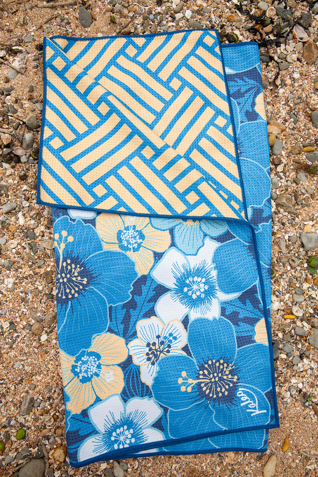 Puarangi hibiscus beach towel with vibrant blue, yellow, and white floral design – quick-dry lightweight towel inspired by native New Zealand flowers, perfect for summer and coastal adventures.