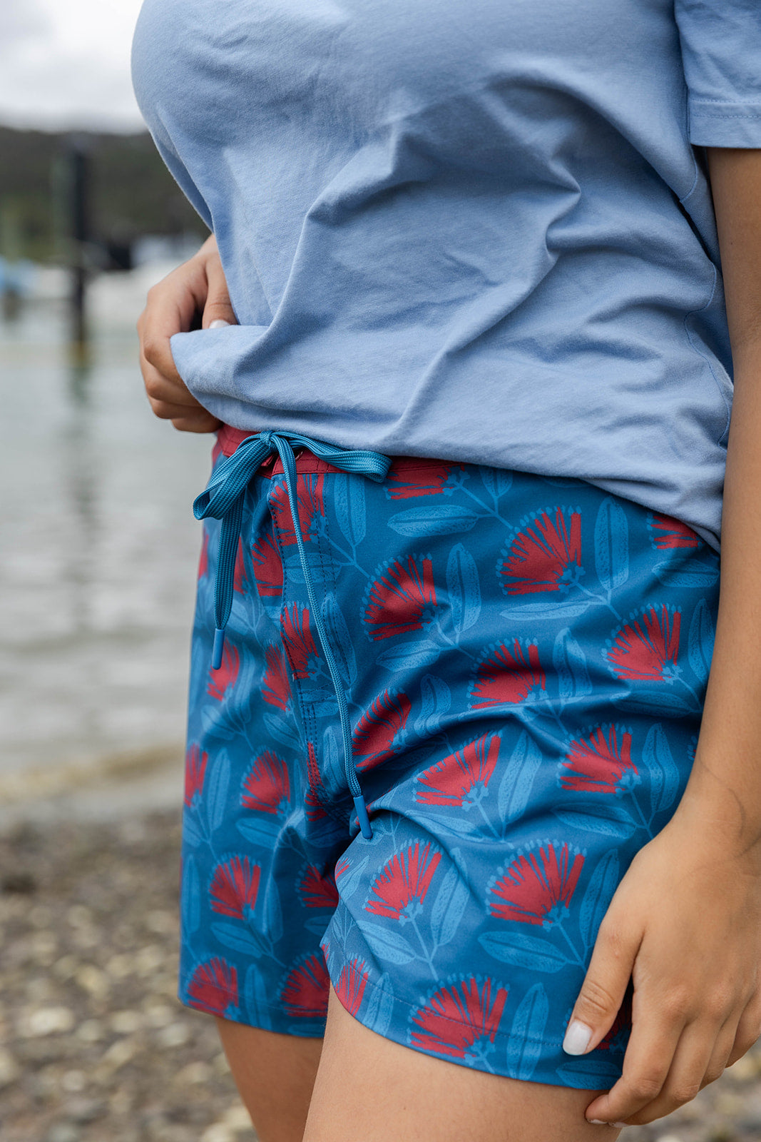 Women’s beachwear NZ – Pōhutukawa print board shorts, NZ-designed lightweight quick-dry boardies by Kaleo; travel-friendly holiday clothing with Kiwi style.