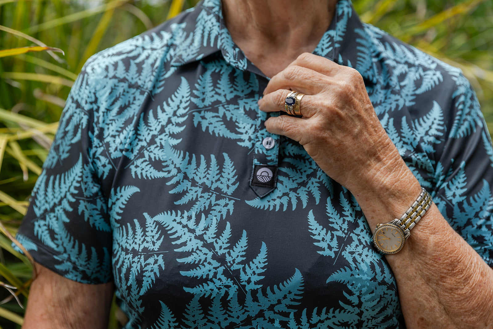 Women’s teal golf polo shirt with silver fern print – breathable, stylish activewear for comfort and performance on the course by Kaleo
