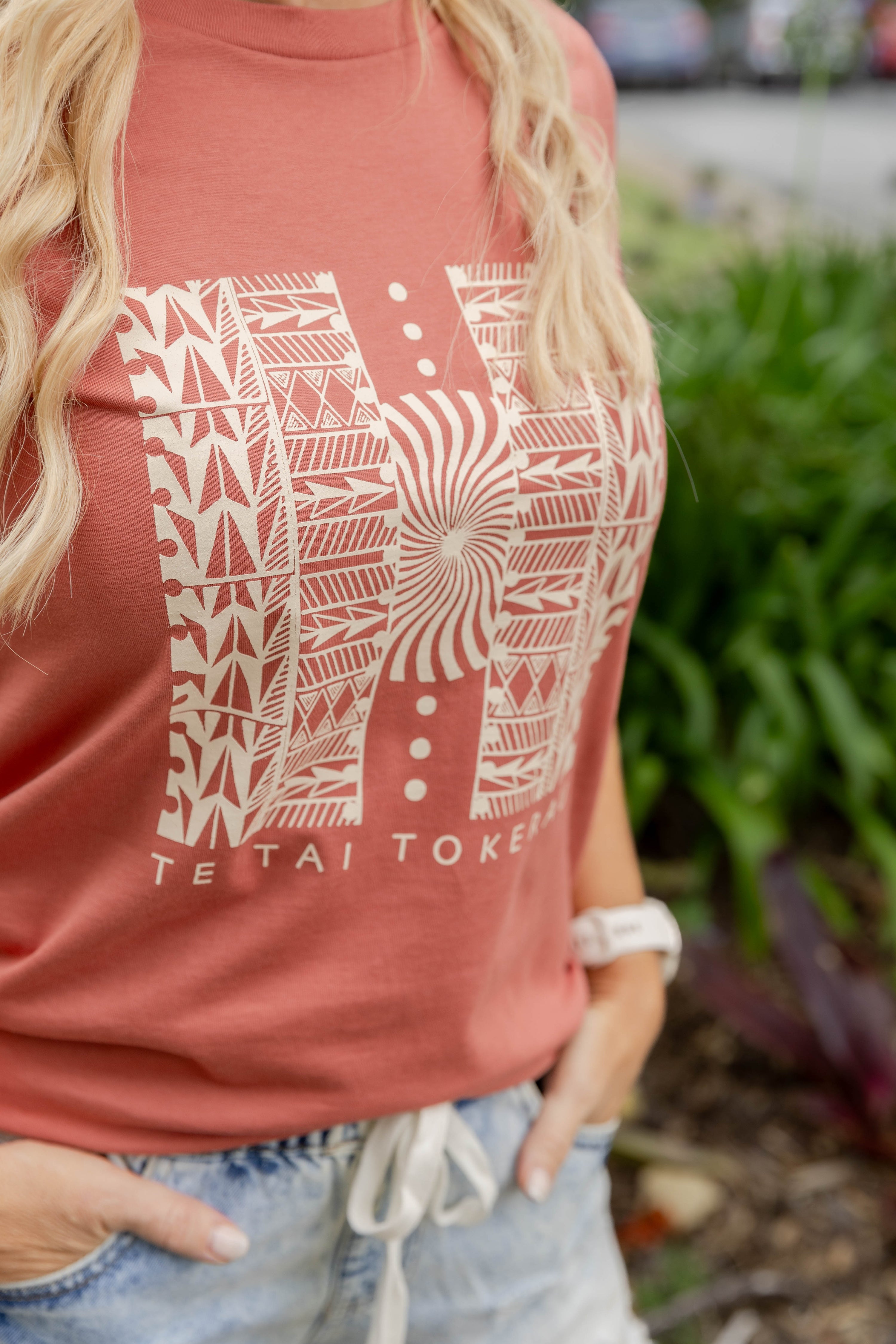 Women’s T-shirt New Zealand – Te Tai Tokerau design in coral, NZ-designed Kiwi T-shirt with Māori-inspired artwork by Kaleo; soft, everyday wearable art.