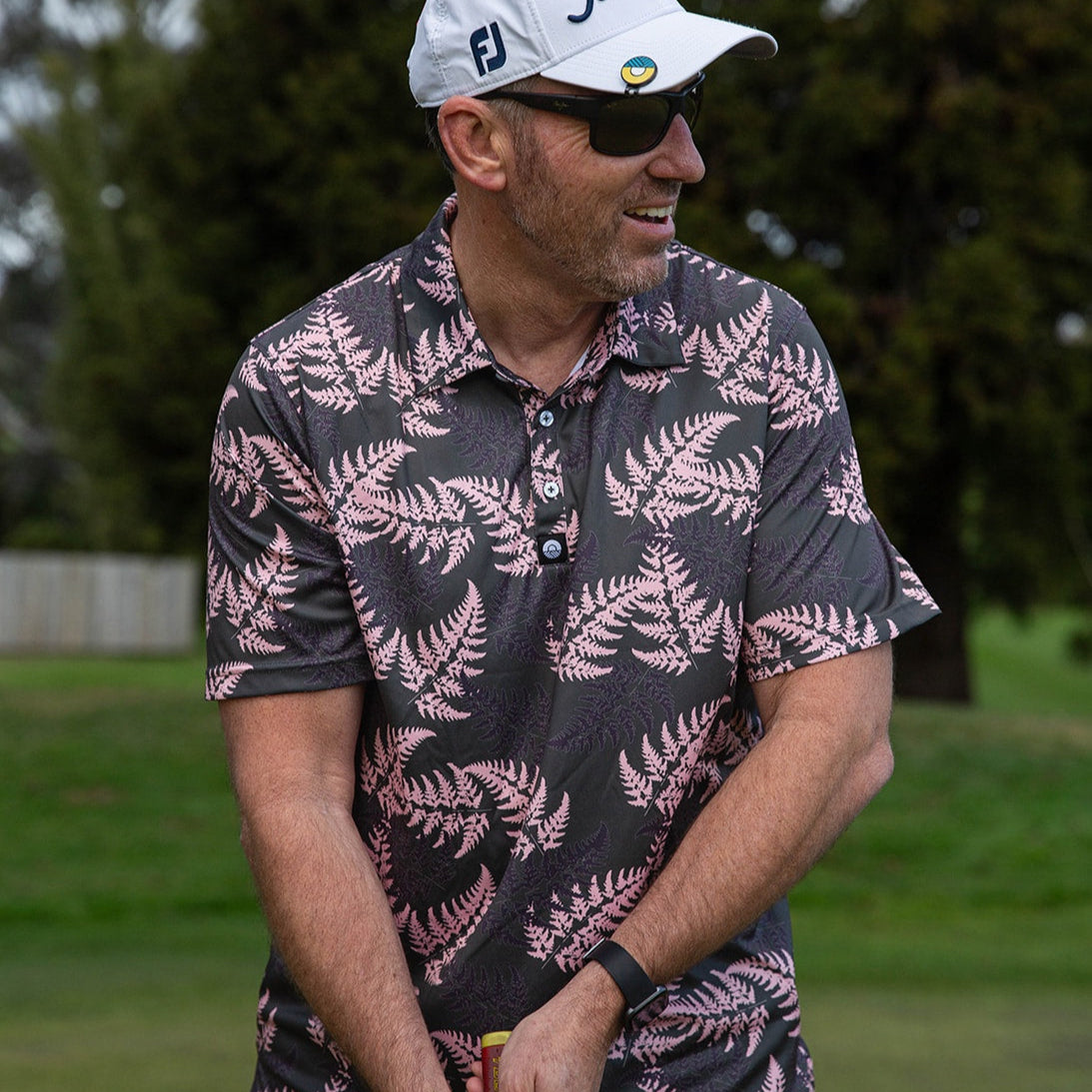 Men’s pink and black golf polo with silver fern print. NZ-designed performance polo shirt for golf, summer wear, and casual Kiwi style.