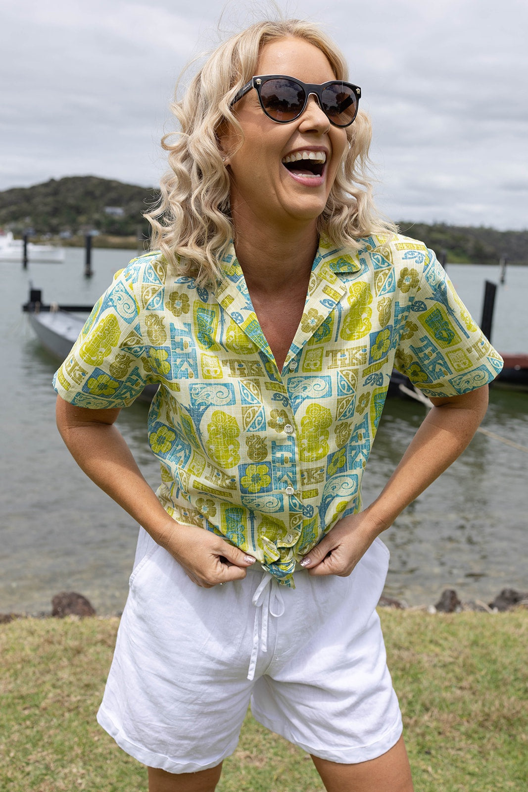 Women’s Tiki Kiwi Classic short sleeve shirt in vibrant green, yellow, and aqua Polynesian-inspired print. Lightweight breathable cotton blend, perfect for summer holidays, beachwear, and resort fashion in New Zealand. Features bold tiki and manaia motifs with a relaxed fit for casual comfort.