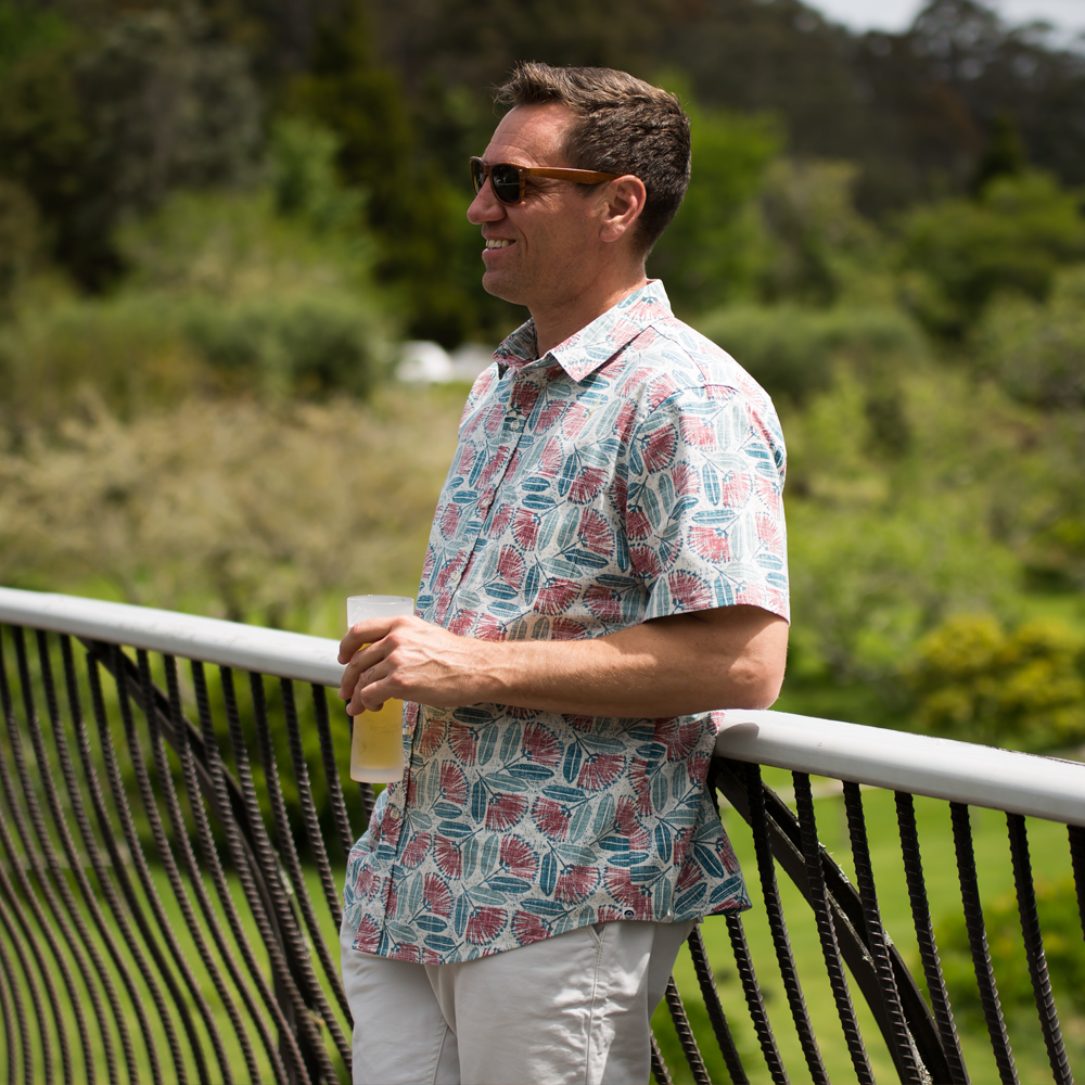 Kaleo Pohutukawa in Bloom men’s Kiwi Classic short sleeve shirt, featuring red and green pohutukawa floral print, New Zealand summer fashion.